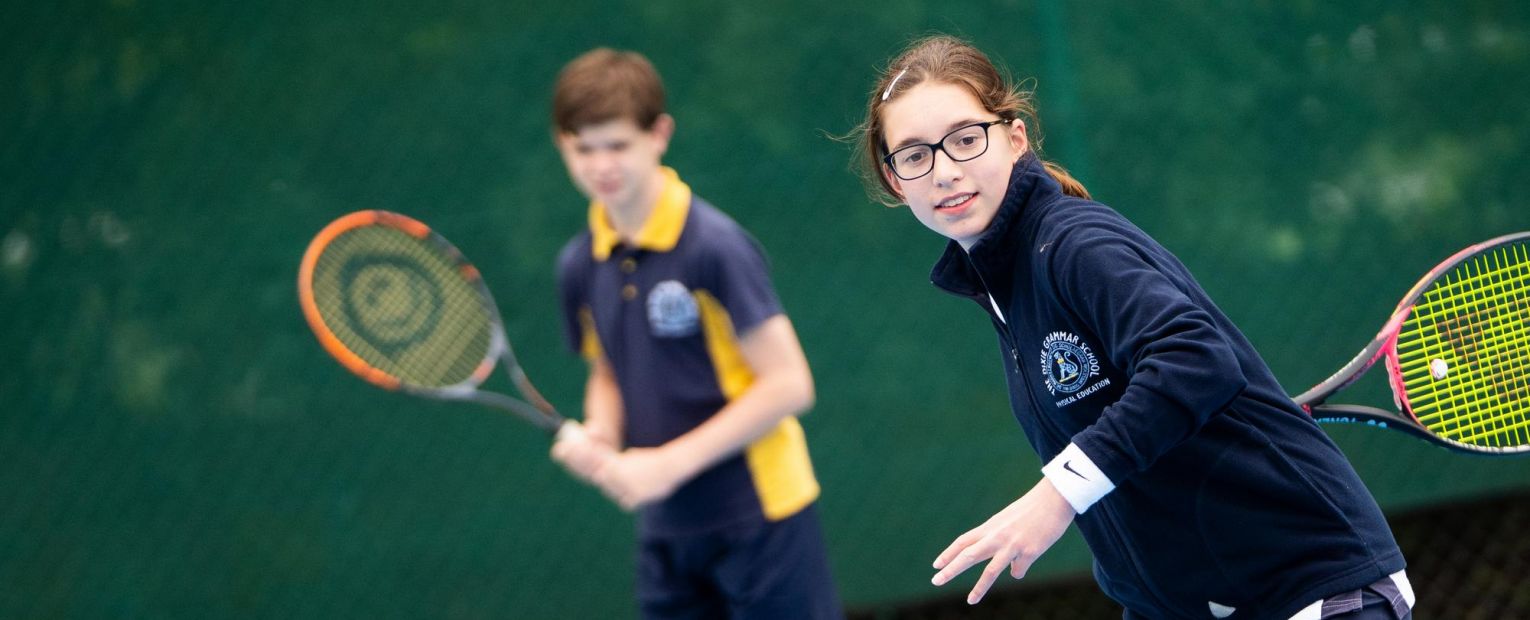 school children playing tennis