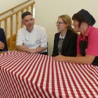 students sat around a table with a chef