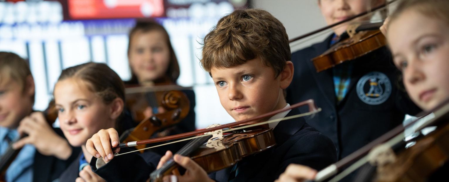 school children playing string instruments