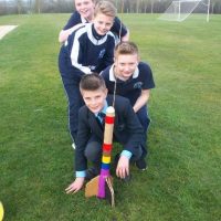 boys standing next to a card board rocket