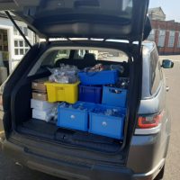 A car boot with PPE equipment inside boxes