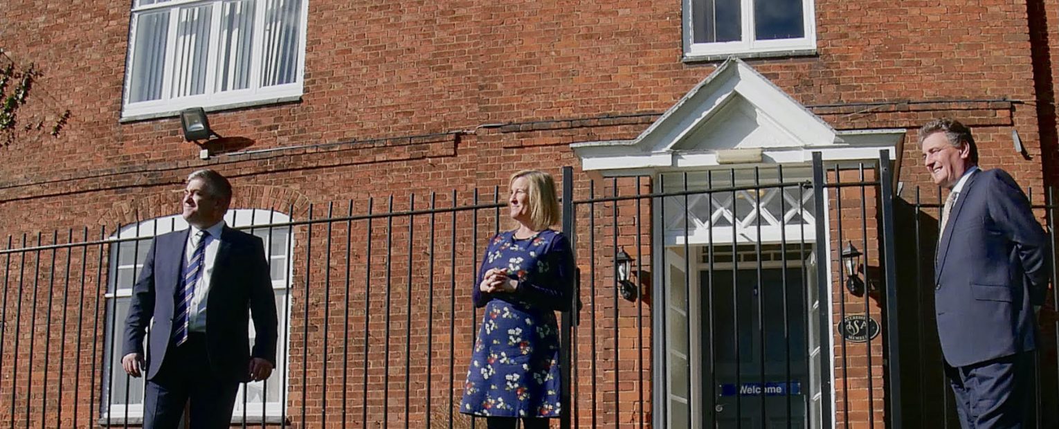 3 teachers stood outside the school