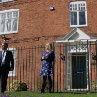 3 teachers stood outside the school