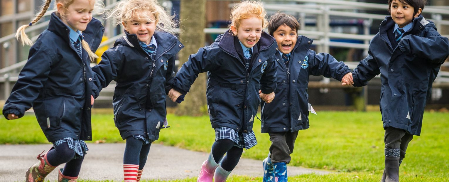 Students running across the school with wellies